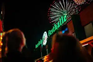 Die Auerbräu-Festhalle am Rosenheimer Herbstfest, in der Nacht mit Feuerwerk im Hintergrund