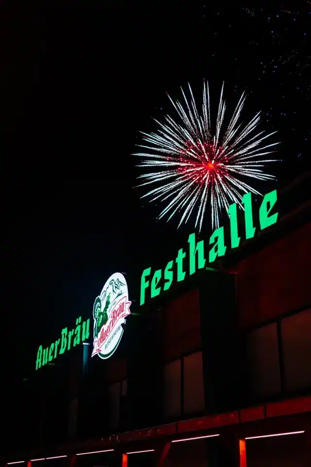 Die Auerbräu-Festhalle am Rosenheimer Herbstfest, in der Nacht mit Feuerwerk im Hintergrund