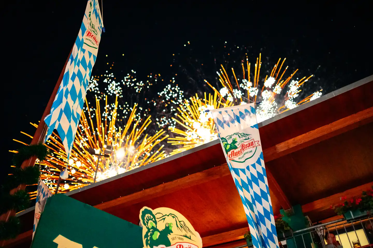 Auerbräu Biergarten am Rosenheimer Herbstfest, in der Nacht mit Feuerwerk im Hintergrund