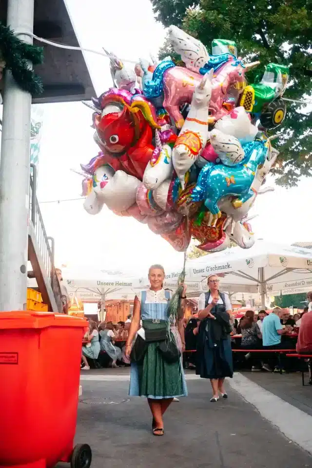 Frau in Tracht auf dem Rosenheimer Herbstfest mit vielen Ballons in der Hand