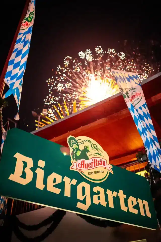 Auerbräu Biergarten am Rosenheimer Herbstfest, in der Nacht mit Feuerwerk im Hintergrund