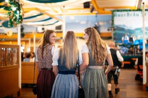 drei junge Frauen in Tracht von hinten, in der Auerbräu-Festhalle am Rosenheimer Herbstfest