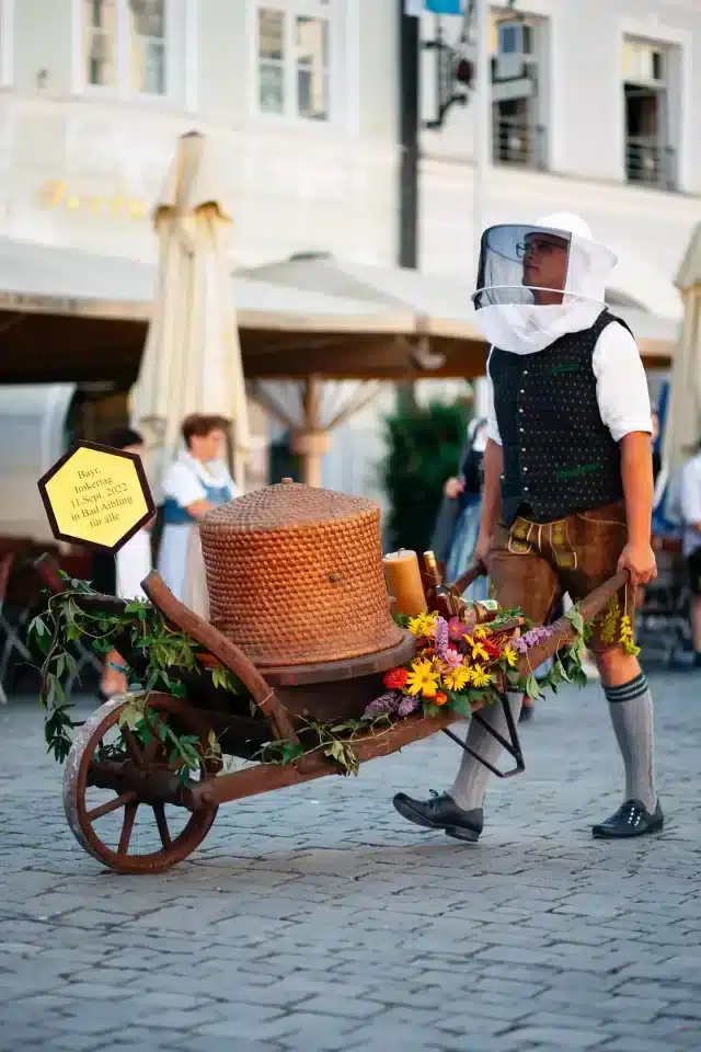 Mann der einen Bienenkarren auf dem Rosenheimer Herbstfest Umzug schiebt