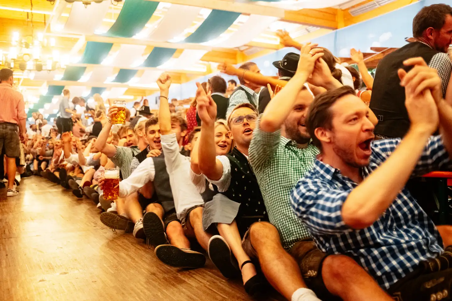 Besucher des Rosenheimer Herbstfestes die in einer Reihe hintereinander sitzen und klatschen