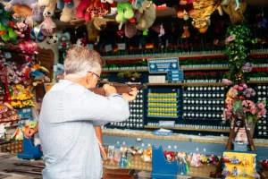 Mann der am Schießstand auf dem Rosenheimer Herbstfest steht und mit einem Gewehr zielt