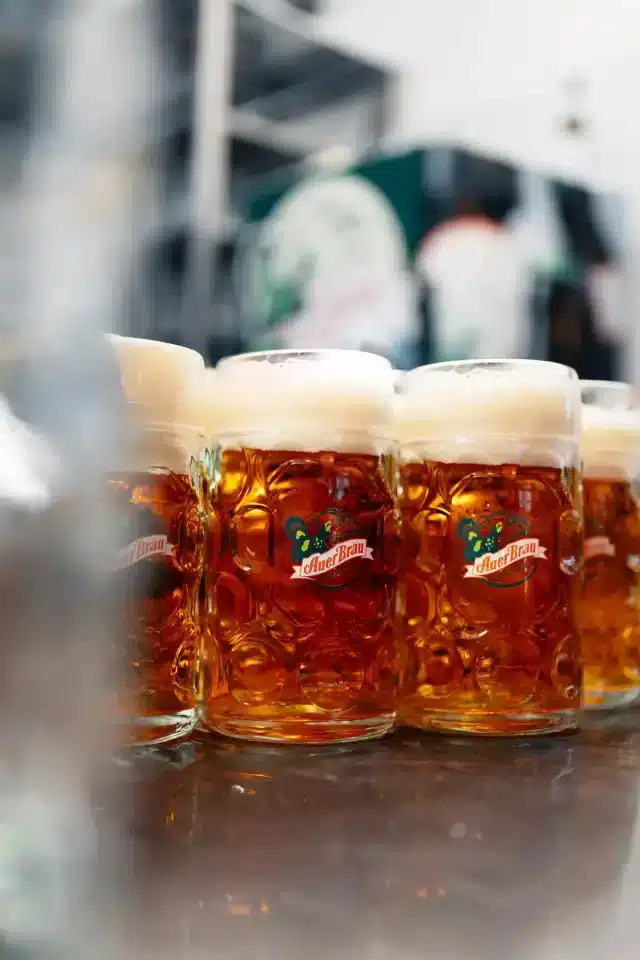 Mehrere Auerbräu-Bierkrüge die gefüllt nebeneinander auf der Ausschenke stehen